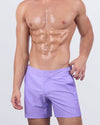 A male model wearing the Neo Violet Tailored Shorts from DC2. The vibrant pastel purple shade adds a sophisticated touch, while the adjustable side buckles and tailored cut ensure a perfect fit.