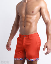 Side view of stretchy men's shorts in ORANGE FLOW a bright vibrant orange color with with two front pockets and custom engraved button front closure with zip fly from DC2.