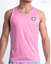 Male model wearing men’s PADAM PINK men’s Summer Tank Top in a pink color with stylish pastel yellow and aqua colored stripes. This high-quality shirt is by DC2, a men’s beachwear brand from Miami.