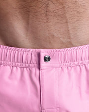 Close-up view of the PADAM PINK men’s swimwear, showing custom branded silver metal logo.