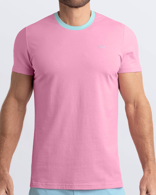 Frontal view of a male model wearing a solid light pink Pima cotton t-shirt with a light blue collar, crafted for stylish casual wear and beachwear by DC2 Miami. Premium quality men&