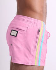 Side view of the PADAM PINK for men’s summer Poolside Shorts with dual zippered pockets. The shorts are in a solid pink color with side pastel yellow and light blue stripes for men made by DC2 a brand based in Miami.