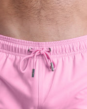 Close-up view of the PADAM PINK men’s summer shorts, showing pink cord with custom branded silver cord ends, and matching custom eyelet trims in silver.