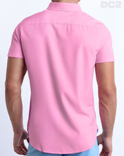A male model is seen from the back wearing a white PADAM PINK a Hawaiian shirt from DC2, a Miami-based men’s beachwear brand. 