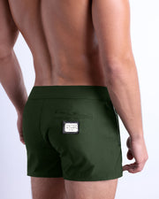 Side view of the PALM GREEN Summer Beach Shorts with dual zippered pockets for men featuring a solid green color is designed by BANG! Clothes in Miami.