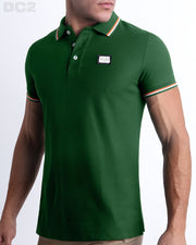 Male model wearing a slim-fitting, PALM GREEN Pima Cotton Polo Shirt by Miami-based DC2. Solid dark green with white and orange stripes on ribbed-knit collar and cuffs.