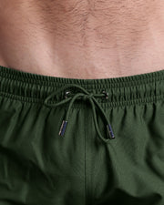 Close-up view of the PALM GREEN men’s summer shorts, showing green cord with custom branded silver cord ends, and matching custom eyelet trims in silver.