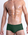 Front view of model wearing the PALM GREEN men’s Swim Sunga in a solid dark green color by DC2, a men's beachwear brand from Miami.