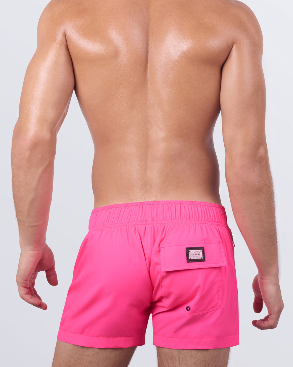 A back view of the PINK BOMB - Flex Shorts, showing the elasticized back waistband, a secure back pocket with a branded patch, and a streamlined silhouette.