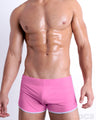 Front view of model wearing the PINKTYQUE men’s swimming bottoms in a solid pink color by DC2, a men's beachwear brand from Miami.