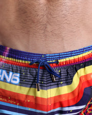 Close-up view of the POOL POSITION men’s summer shorts, showing dark navy blue cord with custom branded golden cord ends, and matching custom eyelet trims in gold.