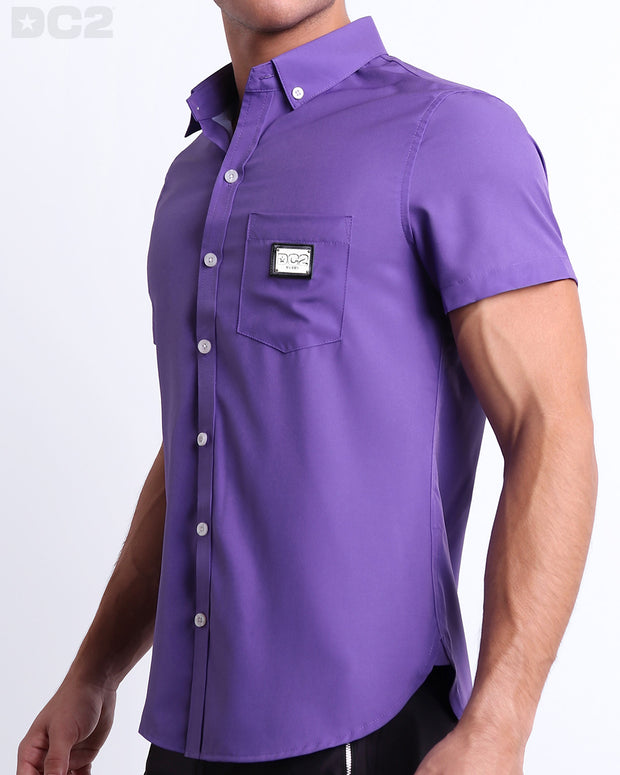 Side view of a masculine model wearing the men’s PURPLE MACHINE Summer button-down shirt in a solid purple color. This high-quality shirt is by DC2, a men’s beachwear brand from Miami.