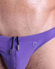 Close-up view of the PURPLE MACHINE men’s drawstring briefs showing black cord with custom branded metallic silver cord ends, and matching custom eyelet trims in silver.