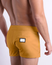 Side view of the RETRO MUSTARD Summer Beach Shorts with dual zippered pockets for men featuring a solid dark yellow color is designed by BANG! Clothes in Miami.
