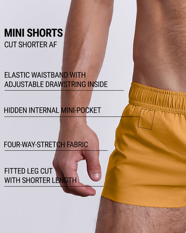 Infographic explaining the many features of the RETRO MUSTARD Mini Shorts. These MINI SHORTS have elastic waistband with adjustable drawstring inside, hidden internal mini-pocket, 4-way stretch fabric, and are quad friendly with fitted leg cut with shorter leg length. 