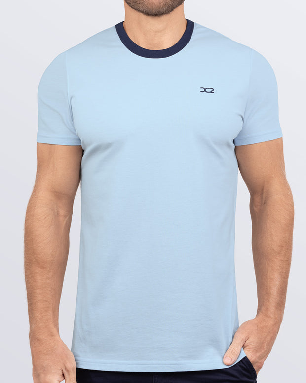 Frontal view of a male model wearing a light blue Pima cotton t-shirt with a bold navy blue collar, crafted for stylish casual wear and beachwear by DC2 Miami. Premium quality men&