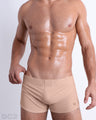 Front view of model wearing the SKINNY DIP men’s swimming bottoms in a solid nude color by DC2, a men's beachwear brand from Miami.