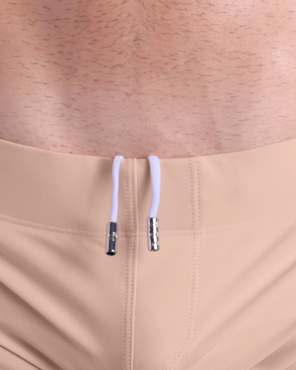 Close-up view of men’s summer beach shorts by DC2 clothing brand, showing white cord with custom branded metallic silver cord ends.