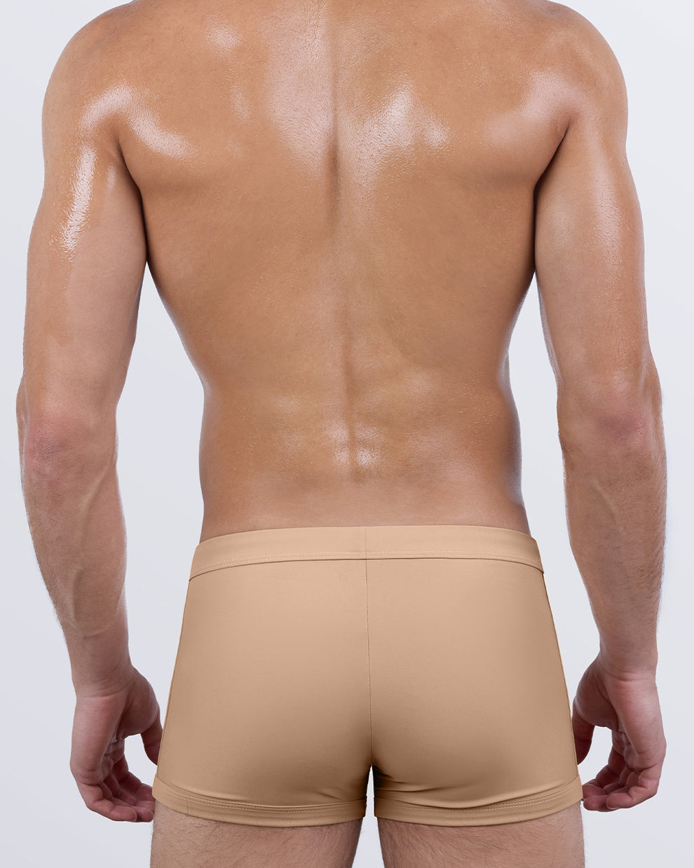 Back view of SKINNY DIP (MEDIUM) tan men's swim trunks by DC2 Miami showcasing seamless rear design and body-contouring fit.