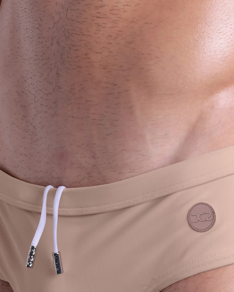 Detail close-up of SKINNY DIP (LIGHT) swim briefs — highlighting internal drawstring, tonal logo patch, and premium stitching.