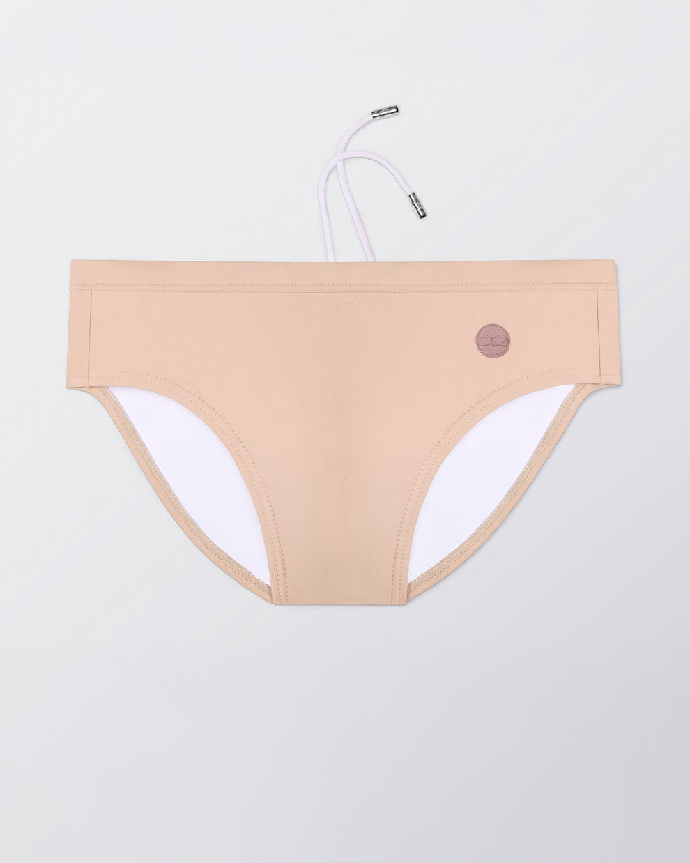 Flat lay of the DC2 Skinny Dip (Light) Swim Brief, featuring a soft neutral tone and sleek, sculpted swim brief design.