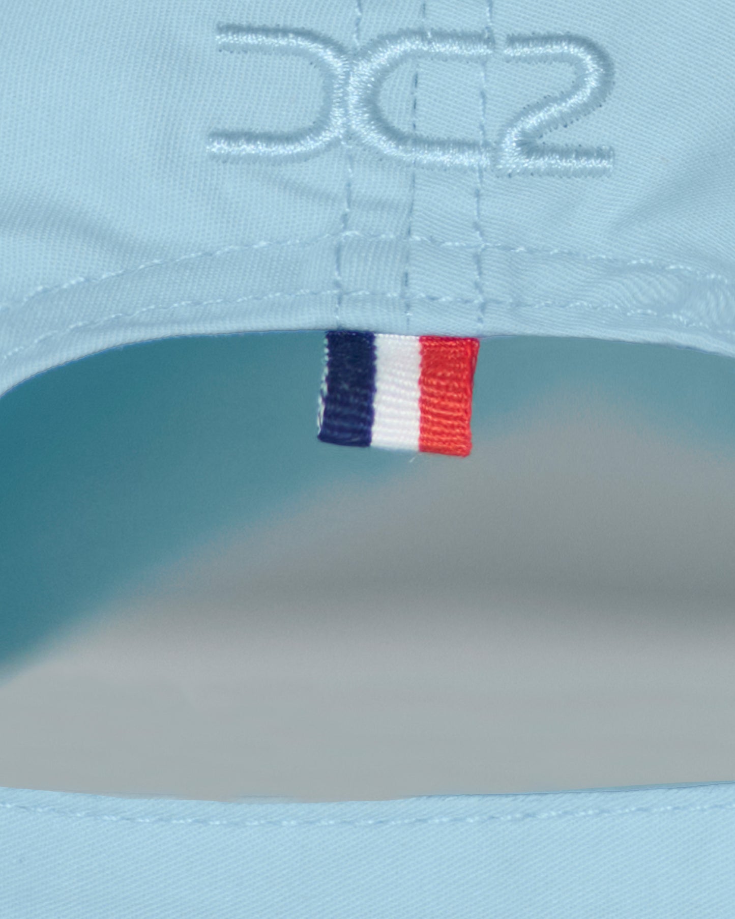 Back detail of the DC2 Resort Cap in Sky Blue — featuring tonal stitching and a woven tricolor accent tab.
