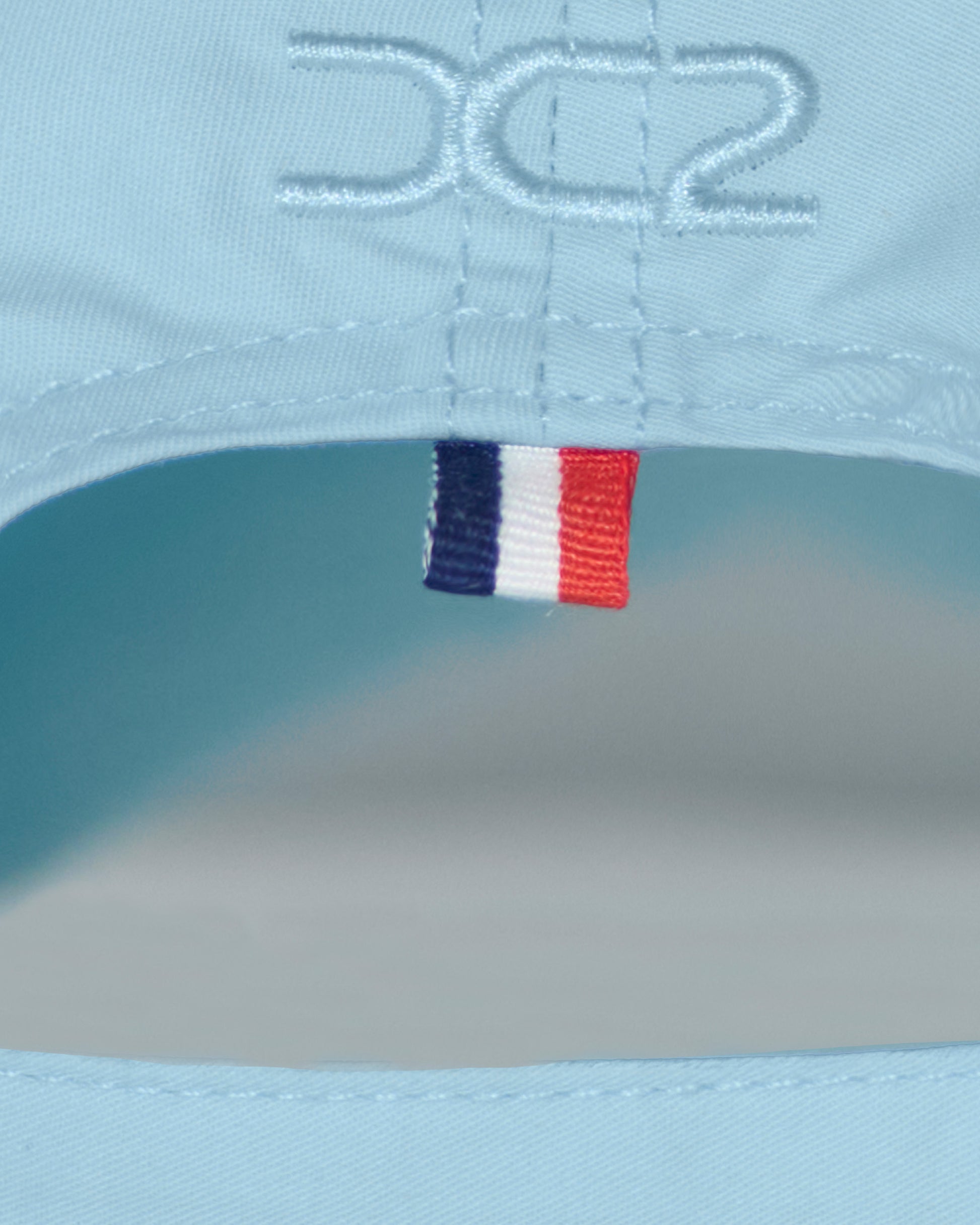 Back detail of the DC2 Resort Cap in Sky Blue — featuring tonal stitching and a woven tricolor accent tab.
