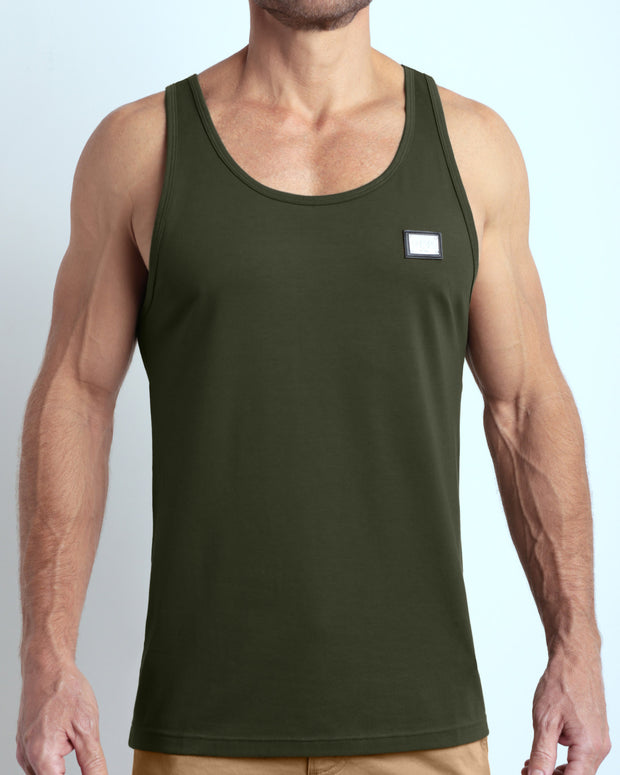 Frontal view of male model wearing the SLICK GREEN in a solid dark green color casual gym tank top for men by the DC2 brand of men&