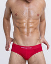 DC2 SOME LIKE IT HOT — model wearing bright red modal briefs, featuring “SOME LIKE IT HOT” text on waistband and sculpted front pouch.