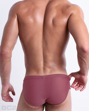 Back view of male model wearing the SUNKISSED RED beach briefs for men by BANG! Miami in a solid red color.