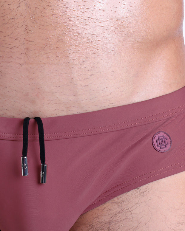 Close-up view of the SUNKISSED RED men’s drawstring briefs showing black cord with custom branded metallic silver cord ends, and matching custom eyelet trims in silver.