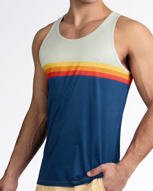 DC2 Sunset Stripes Gym Tank Top — model wearing color-block men’s tank featuring sand upper panel, sunset stripe bands in yellow, orange, and red, and deep navy body.