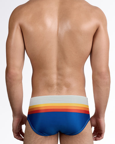 DC2 Sunset Stripes Swim Sunga — back view showing smooth full rear coverage with continuous sunset-inspired stripe detailing wrapping across the back.