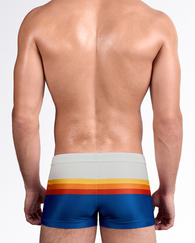 DC2 Sunset Stripes Swim Trunks — back view showing continuous wraparound sunset stripe design against smooth stretch fabric.