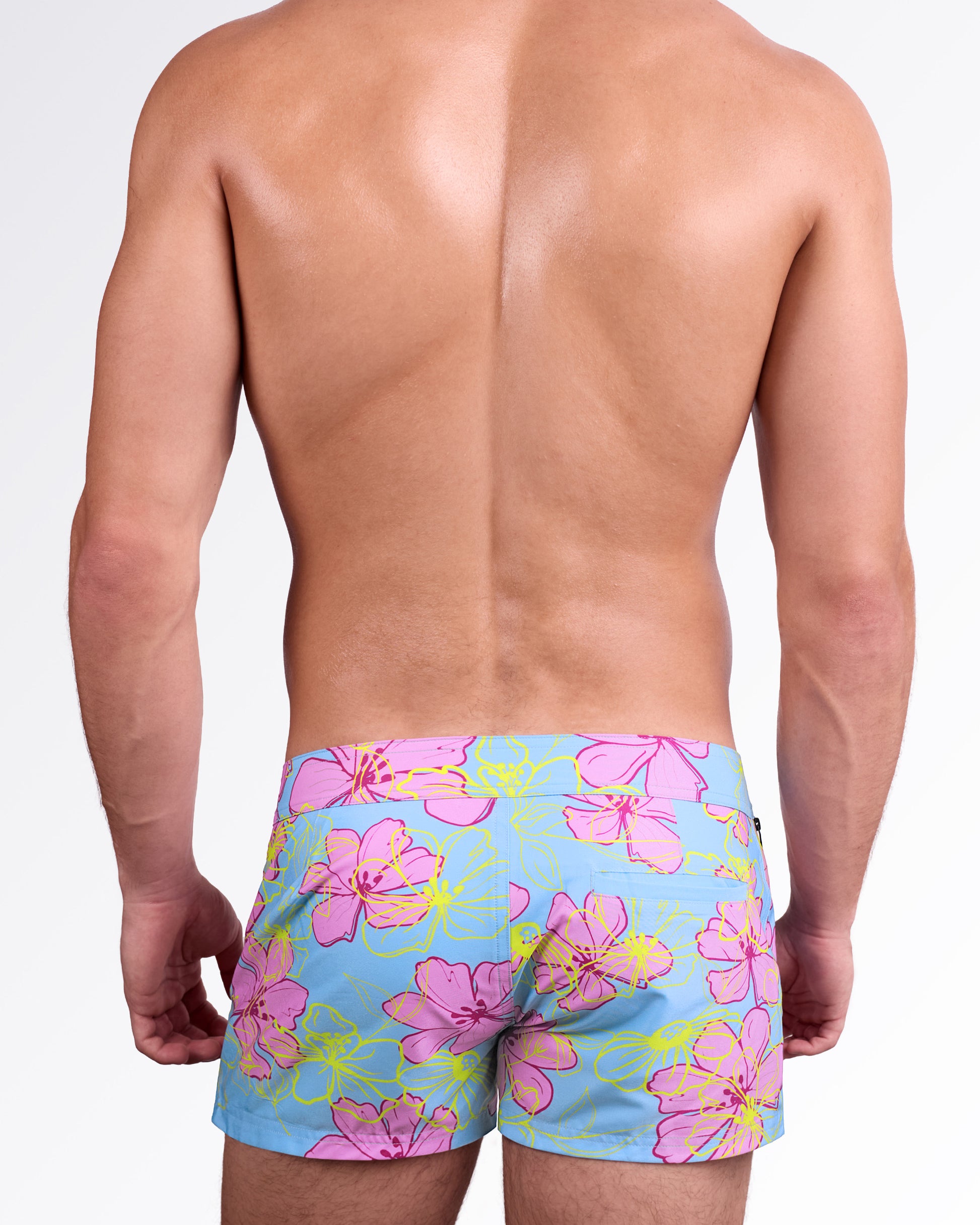 BANG Surf Flowers (Pink/Blue) Beach Shorts — front view highlighting the bold tropical floral print, structured waistband with button detail, and sleek resort-ready design.