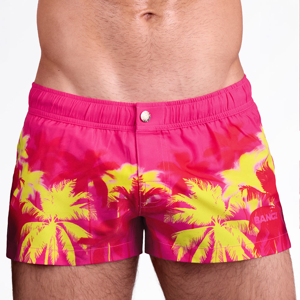 BANG Surf Flowers (Pink/Blue) Mini Shorts — front view featuring a vibrant pink base with bold yellow palm silhouettes and a tailored mini-length cut designed for a sleek, beach-ready look.