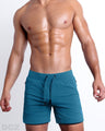 Frontal view of male model wearing the TEAL 2-in-1 Endurance Shorts in a solid teal blue quick-dry by DC2 brand of men's beachwear from Miami.