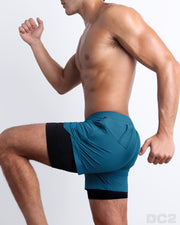 Side view of men’s durable training shorts in a solid teal color made by DC2 the official brand of mens sportswear.