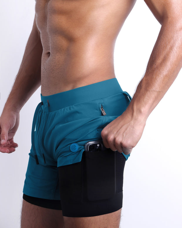 Side view of men’s triaining  in a solid teal color with interior compression phone pocket made made by DC2 the official brand of mens sportswear.