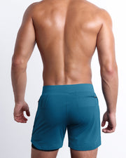 Back view of the TEAL men's fitness compression lined workout shorts in a dark blue/green color. These premium quality quick-dry endurance shorts are DC2 by BANG! Clothes, a men’s beachwear brand from Miami.