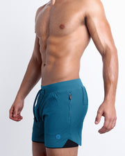 Side view of men’s performance exercise shorts in a solid teal color made made by DC2 the official brand of mens sportswear.