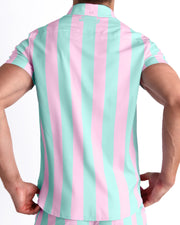 Male model wearing men’s THE KEN (MALIBU EDITION) men’s Summer button-down, featuring pastel pink and aqua-colored stripes. 