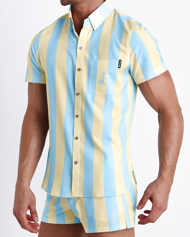Side view of the THE KEN (MIAMI EDITION) men’s Summer button down inspired by the Barbie movie SoBe/Art-Deco-inspired pastels in yellow and blue stripes with front pocketand the matching Show Shorts by Miami based Bang brand of men&