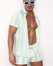 Front view of the THE KEN (MIAMI EDITON) men’s sleeveless stretch shirt with a pastel blue and yellow stripes and matching Show Shorts by the Bang! brand of men's beachwear from Miami.