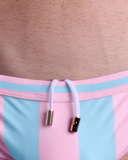 Close-up view of the THE KEN (IBIZA EDITION) men’s drawstring briefs showing white cord with custom branded golden cord ends, and matching custom eyelet trims in gold.
