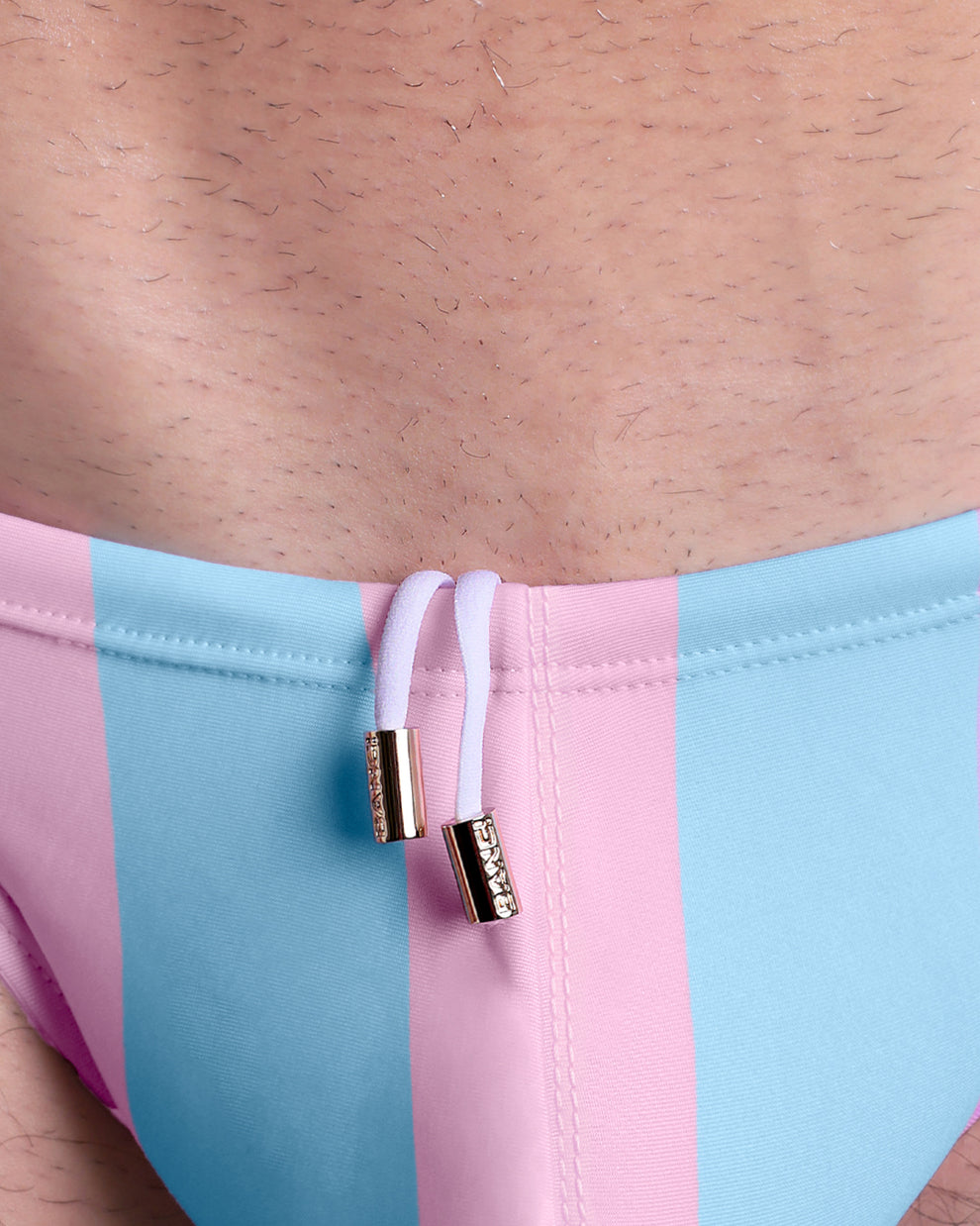Close-up view of the THE KEN (IBIZA EDITION) men’s summer Swim Mini-Briefs by BANG! clothing brand, showing white cord with custom branded golden cord ends, and matching custom eyelet trims in gold.