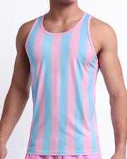 Male model wearing THE KEN (IBIZA EDITION) casual Tank Top, a premium quality tank top in pink and light blue stripes inspired by the styles seen worn by Ryan Gosling as Ken, in the Barbie movie. Designed by BANG! Clothes, a men’s beachwear brand from Miami.