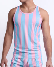 Male model wearing THE KEN (IBIZA EDITION) casual Tank Top with matching beach shorts, a premium quality tank top in pink and light blue stripes inspired by the styles seen worn by Ryan Gosling as Ken, in the Barbie movie. Designed by BANG! Clothes, a men’s beachwear brand from Miami.