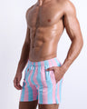 Side view of the THE KEN (IBIZA EDITION) men’s summer Resort Shorts, with dual pockets. The shorts are vibrant with light pink and blue colored stripes, made by BANG! Clothes in Miami.