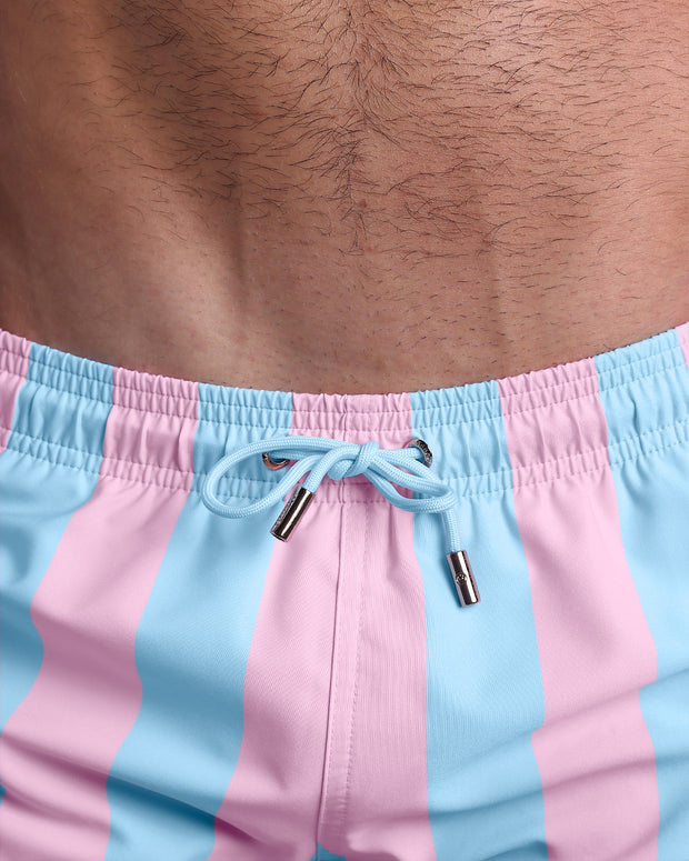 Close-up view of the THE KEN (IBIZA EDITION) men’s summer shorts, showing light blue cord with custom branded golden cord ends, and matching custom eyelet trims in gold.